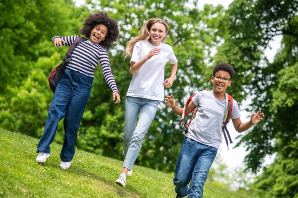公園で遊んでる ブロンドの女の子と2アフリカ系アメリカ人の十代の若者たちが公園で遊んでいる — ストック写真