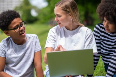 Birlikte çalışalım. Sarışın kız gençlere projelerinde yardım ediyor.