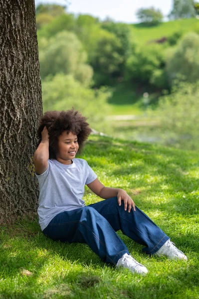 Весела Маленька Дівчинка Сидить Траві Під Деревом Білій Футболці Джинсах — стокове фото