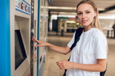 ATM 'de. İş merkezinde ATM 'nin yanındaki uzun saçlı sarışın genç kız.