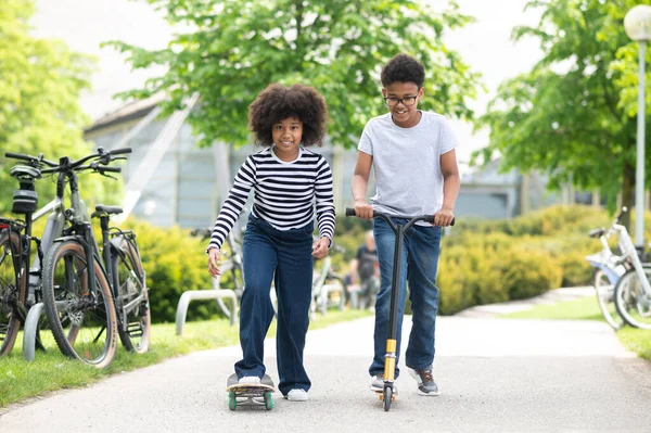 Aktivitäten Park Teenager Mädchen Auf Skateboard Und Junge Auf Roller — Stockfoto