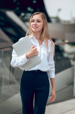 Meşgul kadın. Uzun saçlı, ofis elbiseli, kendinden emin genç bir kadın.