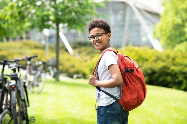 Позитивный Школьник Рюкзаком Белой Рубашке Стоящей Зеленом Парке — стоковое фото