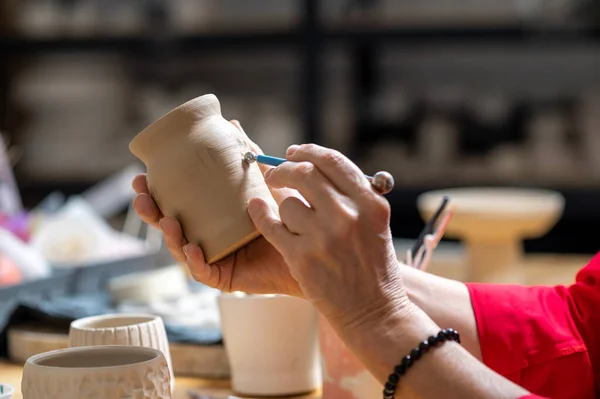 陶芸の研修会の土器の認識できない成熟した女性の絵画 粘土プロダクトを飾る — ストック写真