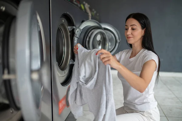 Çamaşırhanede Çamaşırları Sıralayan Çamaşırhanede Çamaşır Makinesi Kullanan Esmer Bir Kadın — Stok fotoğraf
