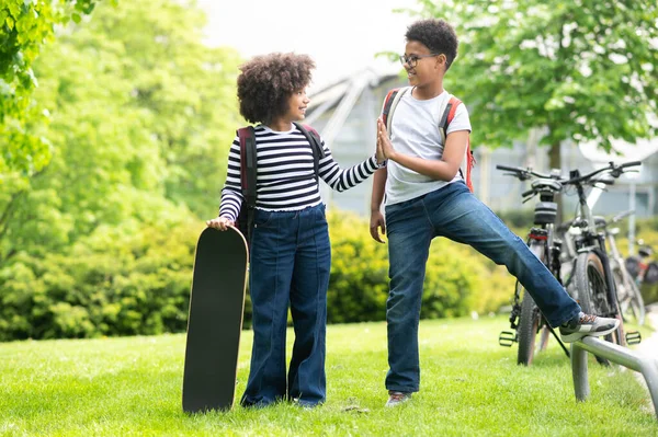 Two Schoolkids Girl Boy Skateboard Green Sunny Park Having Fun — Stock Photo, Image