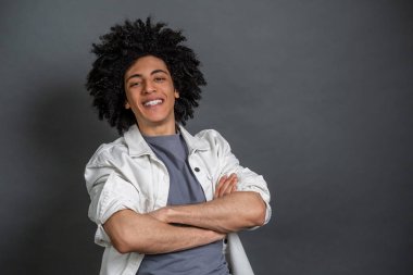 Kendine güven. Genç adam kollarını kavuşturup kendinden emin görünüyor.