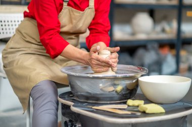 Çömlek atölyesinde çömlekçi çarkında çalışan tanınmayan bir kadın..