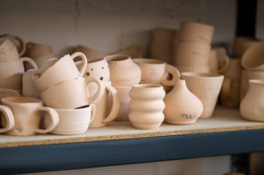 Stüdyoda çömlek rafı, yaratıcı mağaza kil ürünleri, atölyede koleksiyon ve sergi, küçük işletme ve perakende üretim atölyesi