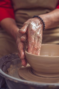 Çömlekçilik ve kil tabaklar üzerinde çalışan tanınmayan bir kadın..