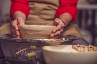 Tanınmayan kadın çömlekçi kilden güzel bir tabak yapıyor, elleriyle sanat eserleri yapıyor..