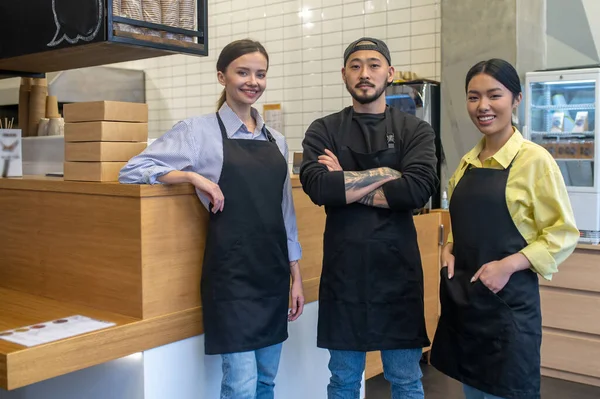 Work Place Team Young Cafe Workers Standing Together Looking Contented — Stock Photo, Image