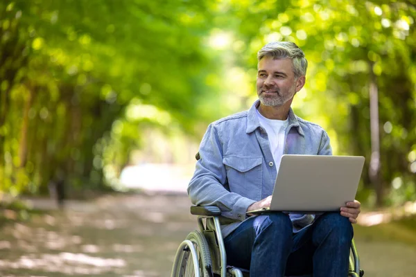 Tekerlekli Sandalyedeki Gri Saçlı Adam Parkta Online Için Dizüstü Bilgisayar — Stok fotoğraf