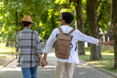 Özgürlük için. Parkta yürüyen ve kaygısız görünen iki genç insan.