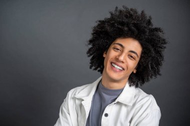 Kendine güven. Beyaz gömlekli, koyu saçlı, kendinden emin genç bir adam.