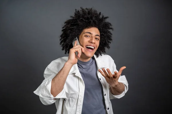 Senang Pemuda Berambut Gelap Berbicara Telepon Dan Tampak Bersemangat — Stok Foto