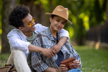 Romantik. Genç, sevimli bir çift çimenlerde oturuyor ve romantik görünüyorlar.