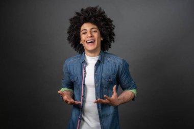 Gülümseyen genç adam. Kıvırcık saçlı genç adam kendini iyi hissediyor ve gülümsüyor.