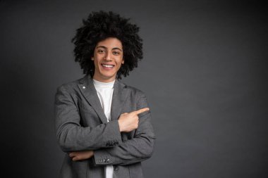 Kendine güven. Gri ceketli genç adam kendine güveni tam duruyor.