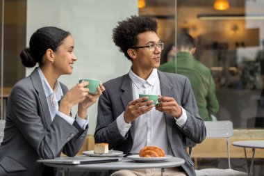 İş meseleleri. Koyu renk saçlı kadın ve iş arkadaşları kahvaltıda iş konularını tartışıyorlar.