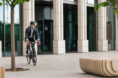 Ofise giden yol. Genç yönetici bisikletle ofise gidiyor.