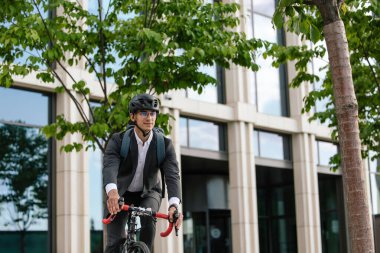 Ofise giden yol. Ofis bölgesinde bisiklet süren etekli bir adam.