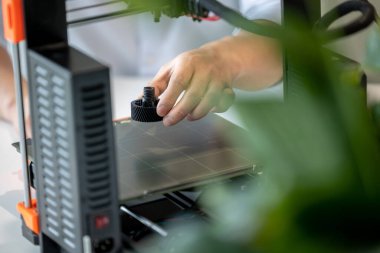 Ofiste 3D yazıcı kullanan tanınmayan erkek tasarımcı, yeni teknoloji fikirleri üzerinde çalışıyor..