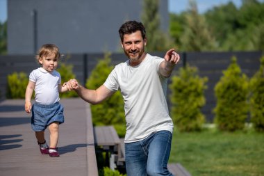 Mutlu bir aile. Mutlu genç baba ve küçük oğlu yürüyüş yaparken