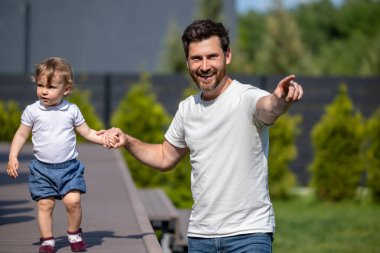 Mutlu bir aile. Mutlu genç baba ve küçük oğlu yürüyüş yaparken