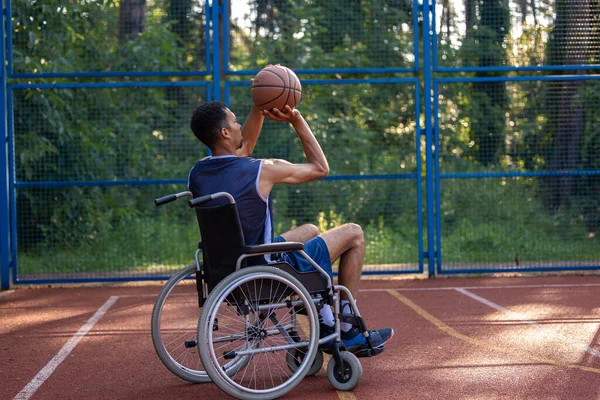 Determination, motivation of person with disability excelling at team sport. Wheelchair basketball payer dribbling ball like professional, ready to shoot and score goal.