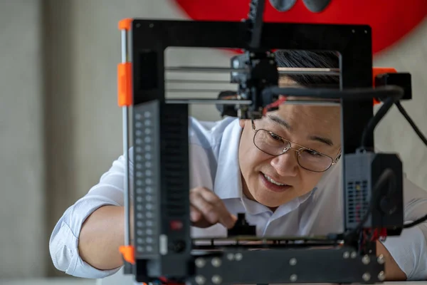 オフィスで3Dプリンターを使用したアジアの男性デザイナー 新しい技術のアイデアと協力 — ストック写真