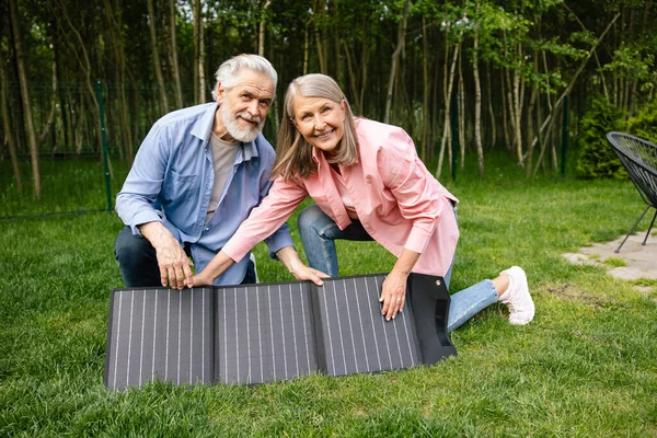 stock image Smiling man and woman showing solar charger, power battery, flexible solar panel.