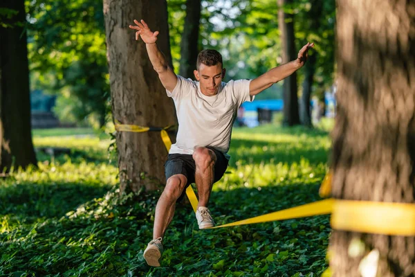 集中する ロープを歩き 焦点を当てているスポーツウェアの若い男 — ストック写真