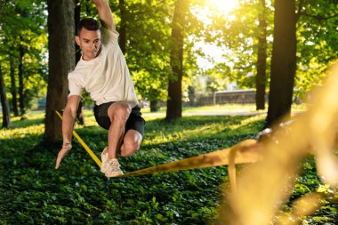 Halatla kayma. Sporcu halatta prastikleşiyor ipe asılıyor ve konsantre görünüyor.
