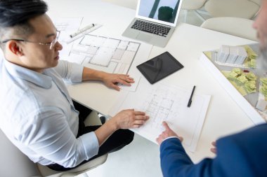 Atölyede mimar, takım çalışması ve tartışmalı plan, inşaat hedefi veya vizyon.