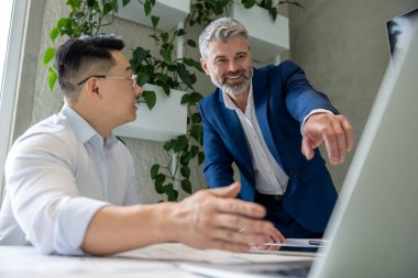 İki mimar dizüstü bilgisayar kullanıyor ve birlikte yeni ev modelliği üzerinde çalışıyorlar..