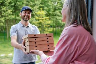 Gülümseyen teslimatçı eve pizza ya da bakkal getiriyor..