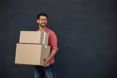 Kutuları olan adam. Ellerinde ağır karton kutularla tatmin olmuş genç bir anne.