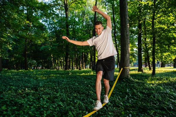 バランス ロープのバランスをとるスポーツウェアの男 — ストック写真