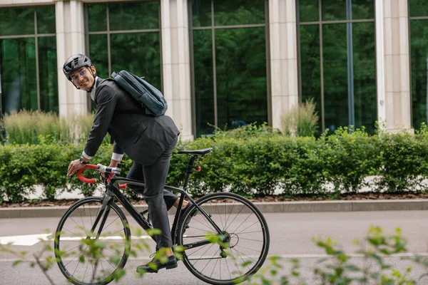 工作的方式 穿着便衣背着背包骑自行车的男人 — 图库照片