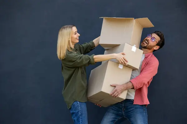 新しい家に移動します 若いカップルは新しい家に移動し 服を持って箱を運ぶ — ストック写真