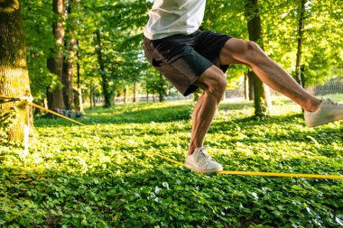 Dengeyi sağlıyorum. İpin üzerinde dengede duran bir adamın resmini kapat.