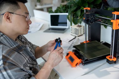 Ürün prototipi, teknoloji ve yenilik kavramında 3D yazıcı kullanan Asyalı tasarımcı mühendisi.