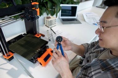 Ürün prototipi, teknoloji ve yenilik kavramında 3D yazıcı kullanan Asyalı tasarımcı mühendisi.