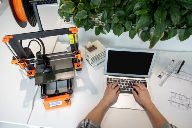 Tanımlanamayan bir adam bilgisayarında boş ekranla yazı yazıyor ve yaratıcı laboratuarda çalışıyor..