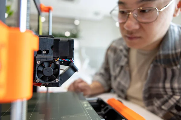 亚洲人检查3D打印机 在实验室用3D打印机制造东西的过程 — 图库照片