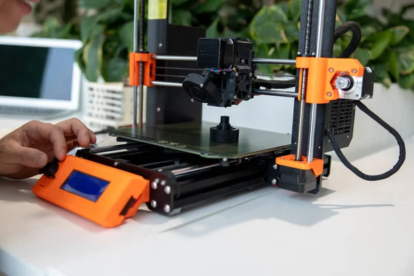 3Dプリンタをチェックする男性のクローズアップ 実験室で3Dプリンタで物を作るプロセス — ストック写真