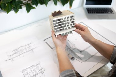 Yaratıcı laboratuarın ışık ofisinde 3 boyutlu yazıcıyla basılmış ev modeli olan tanınmayan bir adam..