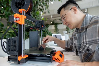 Ürün prototipi, teknoloji ve yenilik kavramında 3D yazıcı kullanan Asyalı tasarımcı mühendisi.