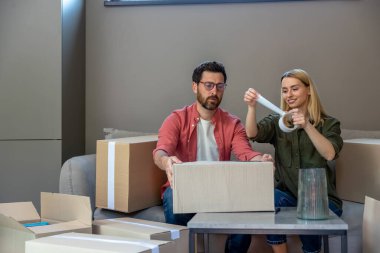 Yeniden yerleştirme. Genç adam ve kadın taşınmak için konteynır paketliyorlar.